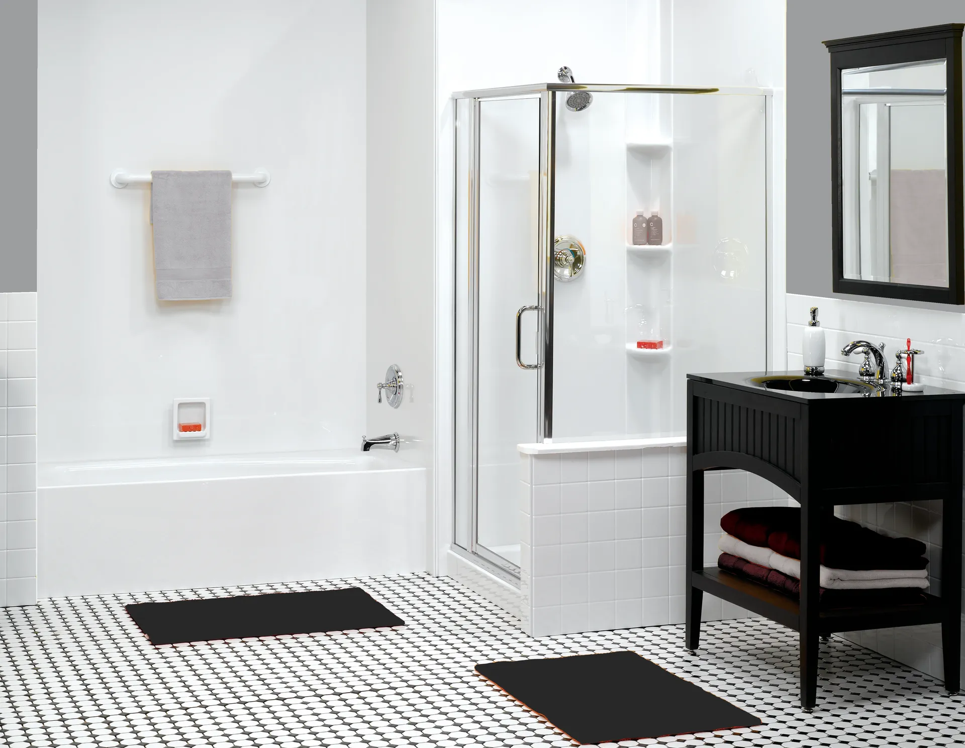 Modern bathroom with a white tub, glass shower, black vanity, and geometric black-and-white floor tiles. The tone is clean and minimalist.